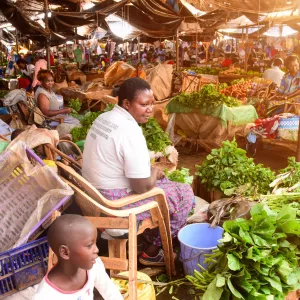 Vendors sitting amid piles of produce.