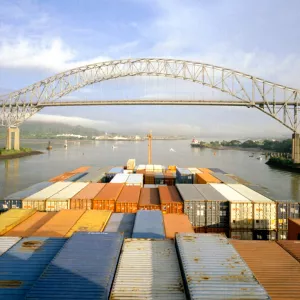 Overhead view of containers on front of ship, foreground, facing bridge in distance.